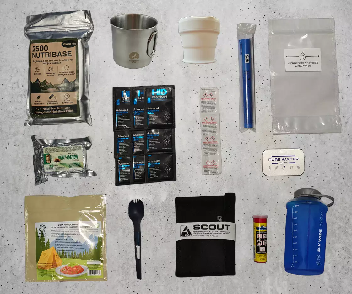 Moduł Wyżywienie rozłożony na betonie: batony NUTRIBASE i NUT-RATION, zupa liofilizowana, elektrolity HID-RATION, kubki, łyżkowidelec, składana kuchenka, filtr do wody, tabletki do uzdatniania i butelka 1 l.